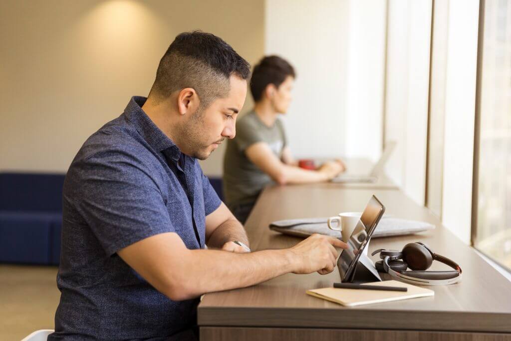 man at desk on tablet